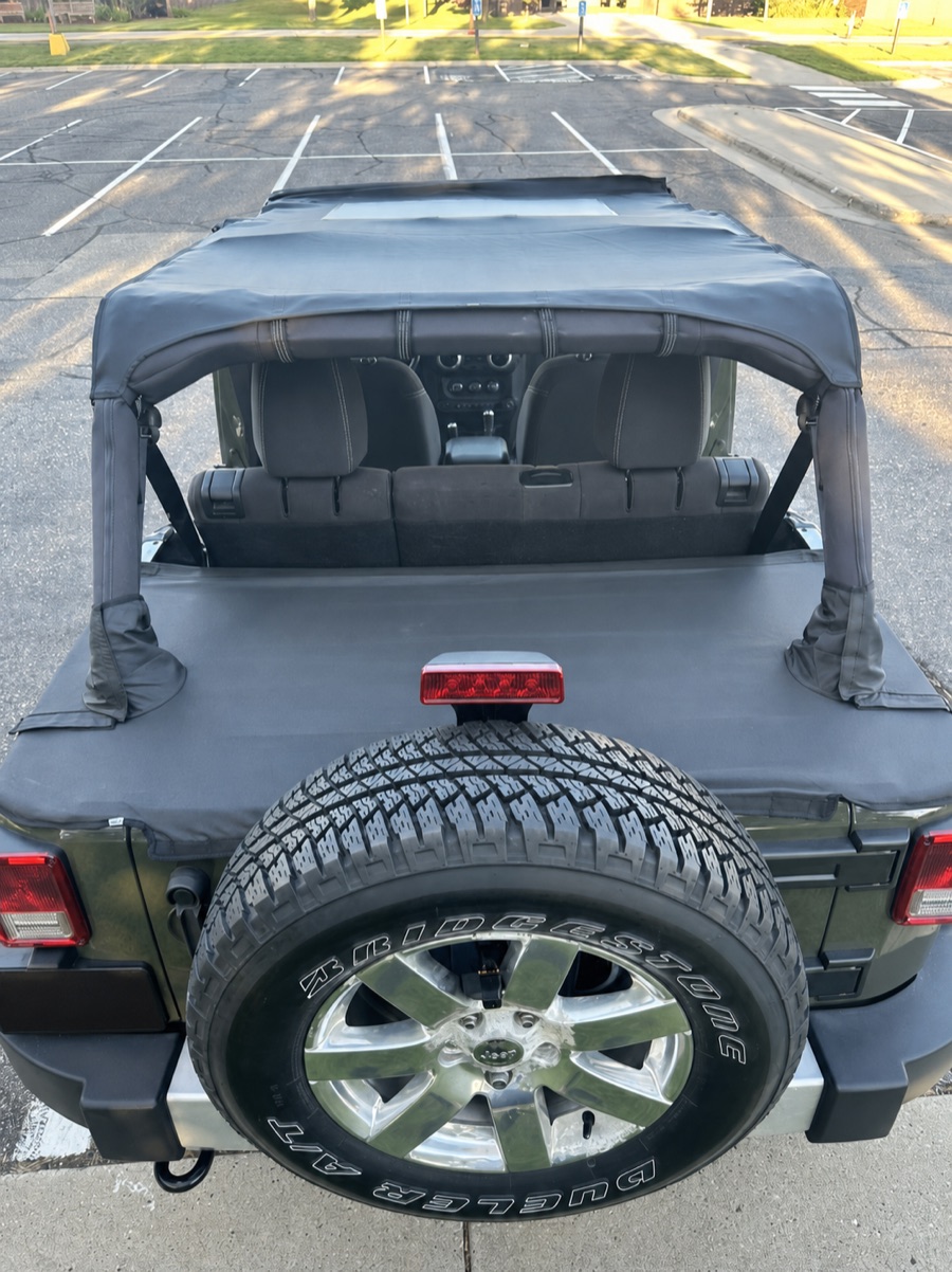 Rear view of the JOYTUTUS tonneau cover on the 2015 Wrangler JKU with license plate information removed
